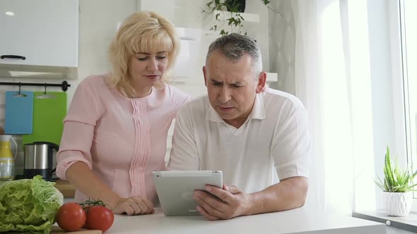 Caucasian Retired Couple Doing Online Shopping Using Tablet