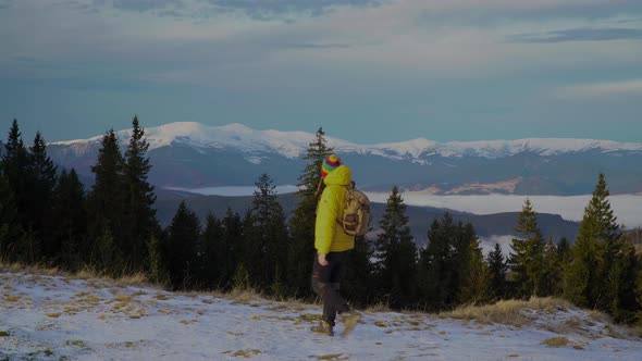 A Man with a Backpack Travels in the Mountains in Winter