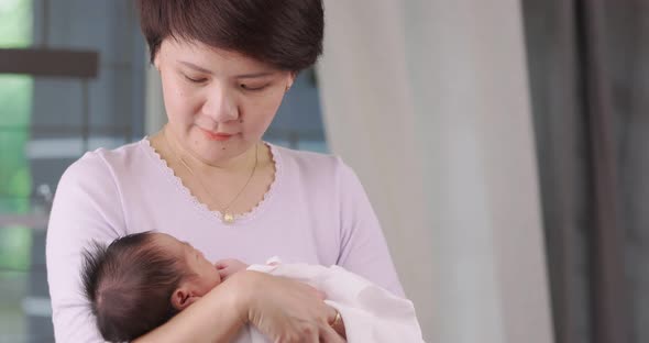 Slow Motion Shot Of Asian Mother Holding Lovely Newborn Carefully  With Love