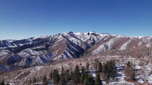 Drone shot panning right to left of a mountain with avalanche damage