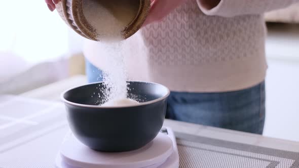 Dough Preparation  Woman Cook Pours Sugar to Ceramic Bowl on Kitchen Scales