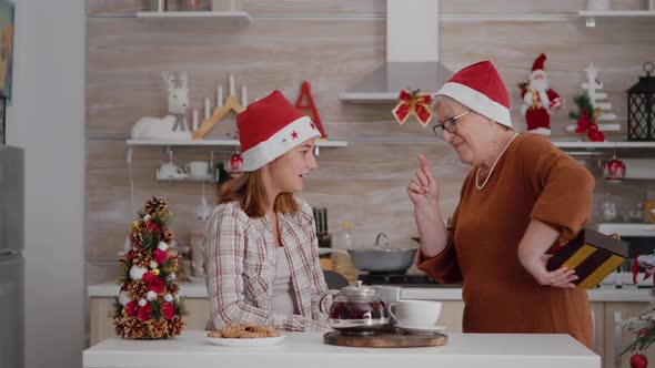 Grandmother Suprising Granddaughter with Wrapper Present Gift During Traditional Winter Holiday