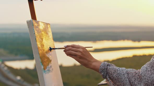 Woman Artist Drawing a Painting on Nature at Sunset Time