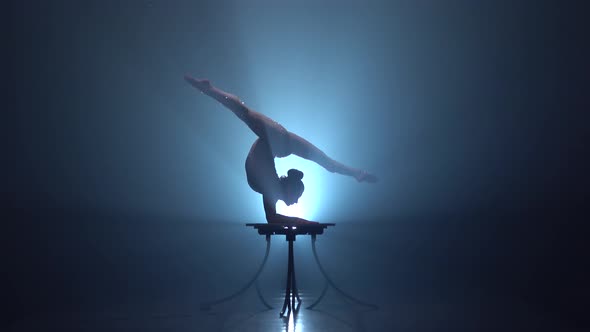 Acrobat on the Table Shows the Tricks of Standing on Her Hands