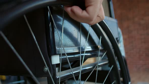Closeup Hand Disabled Man in Wheelchair Turns Wheel and Goes Forward Closeup