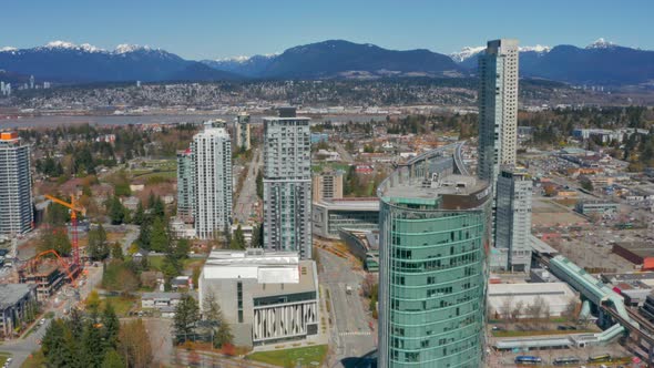 Beautiful drone shot of Surrey City Centre and North Shore Mountains on a sunny summer day in Britis