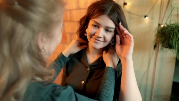 Grown Woman Straightens the Girl's Hair and Clothes