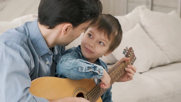 Father Teaches Son To Play the Guitar