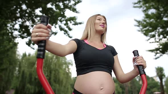 A pregnant girl with a big belly during the third trimester takes part in the sport