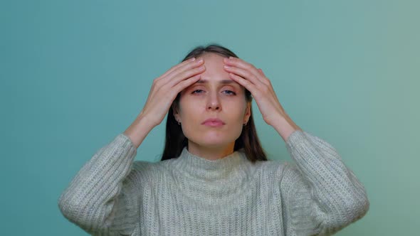 Close up of woman doing facial massage isolated on mint.