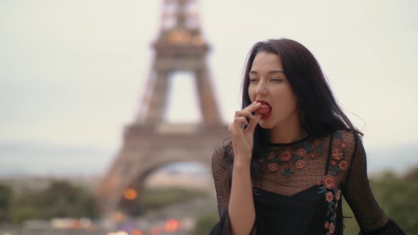 Paris Woman Smiling Eating the French Pastry Macaron in Paris Against Eiffel Tower