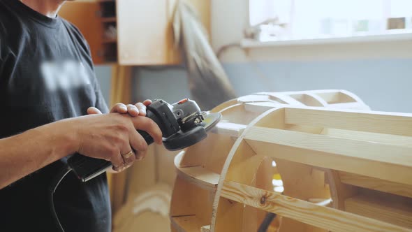 A Professional Carpenter Working with Wood on a Woodworking Machine Grinds and Polishes Wood Closeup