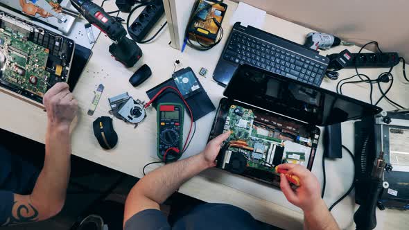 Closeup of Gadget Specialists Fixing Electronic Devices at Workshop