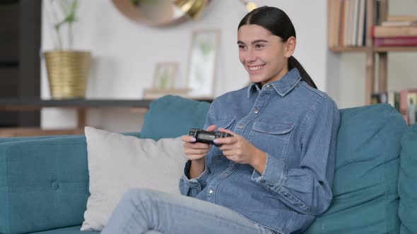 Latin Woman with Success on Video Game on Sofa