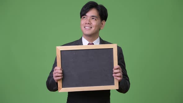 Young Handsome Asian Businessman Showing Blackboard