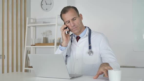 Doctor Talking on Phone with Patient Discussing Medical Report