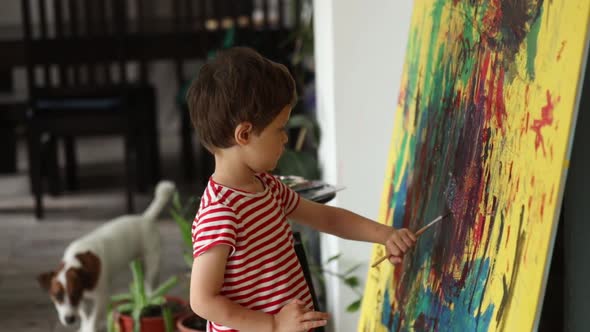 Little boy draw and art with brush and paints at home