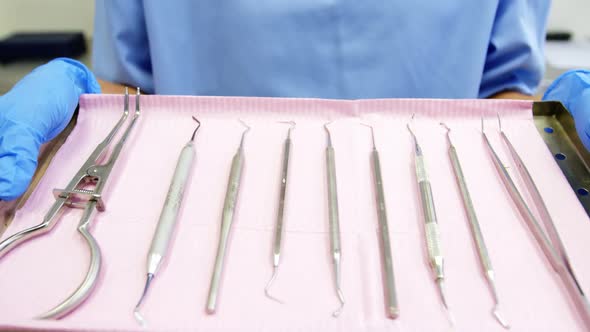 Dental assistant holding tray with equipment