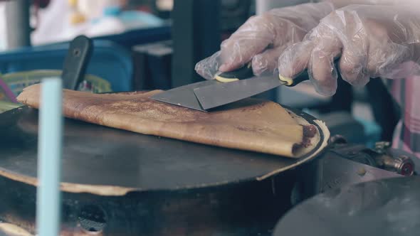 Skilled Chef Folds Made Pancake on Crepe Maker in Cafe