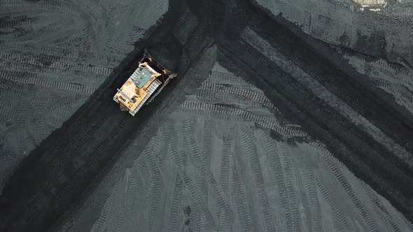 Crawler bulldozer sorts coal into a thermal power plant. Industry. Aerial view.