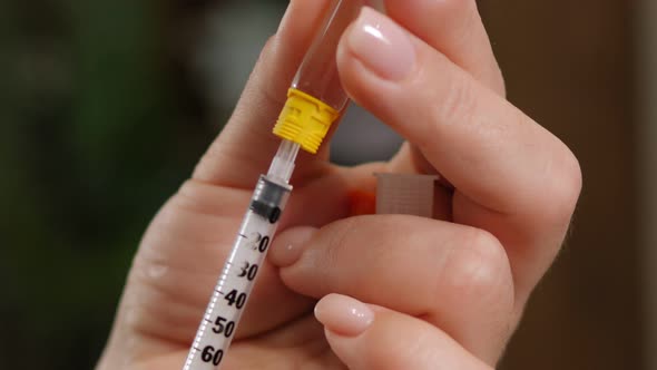 Woman Diabetic with a Syringe and Insulin in Hand Closeup