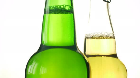 Two bottle of beer rotating on white isolated background