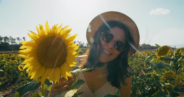 Funny Traveler Girl Hides and Peeking Out From Behind Sunflower on Vacation