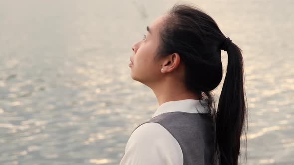 Woman praying alone at sunset. Woman pray for god blessing to wishing have a better life.