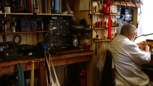 Rear view of horologist repairing a watch