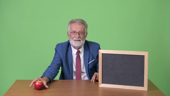 Handsome Senior Bearded Businessman Against Green Background