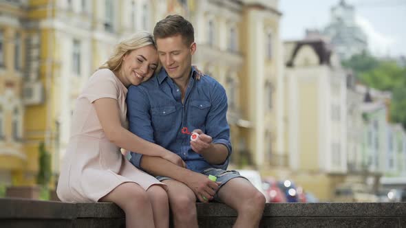 Happy Man and Woman Enjoying Carefree Summer Time, Making Soap Bubbles, Kissing