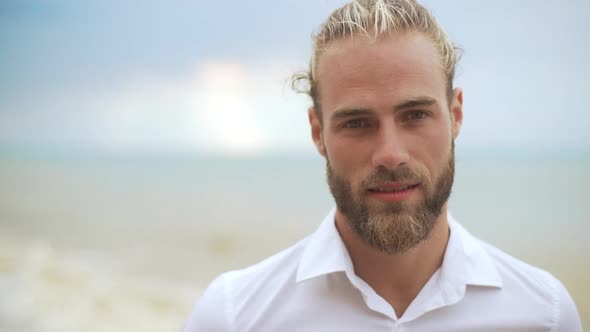 Closeup Goodlooking Blond Haired Gentleman Smiling on Camera Feeling Happy with Sea on Background in