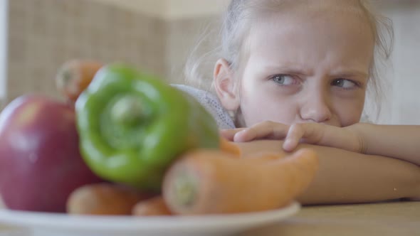 Portrait Little Daughter Angrily Looking at the Plate with Vegetables