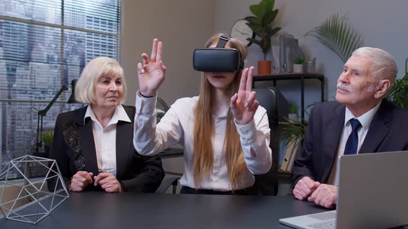 Woman Wearing Virtual Reality Glasses Tries 3D App for VR Helmet While Colleagues Supporting Her