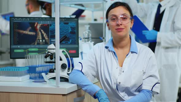 Portrait of Scientist Smiling at Camera Sitting in Modern Laboratory