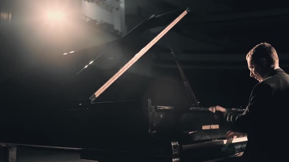 Professional Handsome Pianist in Dark Suit Playing on a Grand Piano on Big Stage