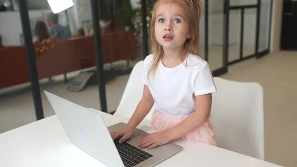 Little Girl Using Tablet Computer Sitting at Table