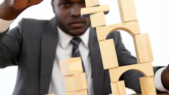 Businessman playing with building blocks