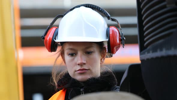 Smiling female technician holding drill and looking at camera
