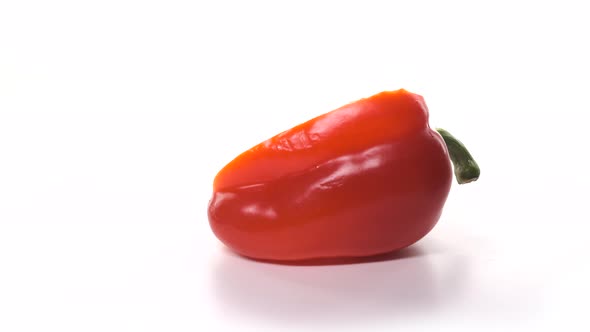 One Fresh Cut Half Red Pepper is Spinning on White Background