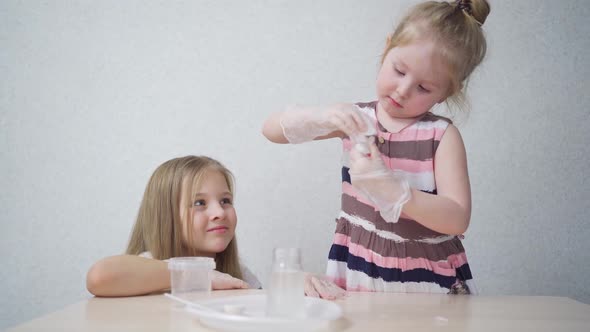 Cute Little Girls in Protective Gloves Prepare for Experiments at Home