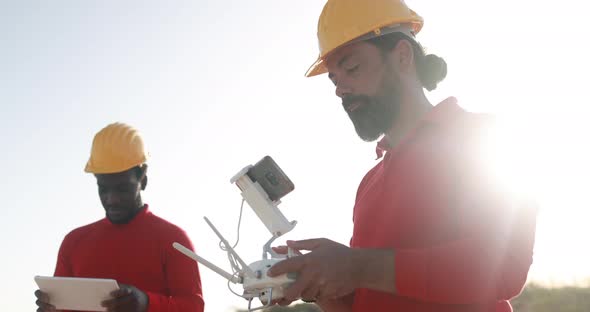 Multiracial engineer men working together on a windmill farm using digital tablet and drone