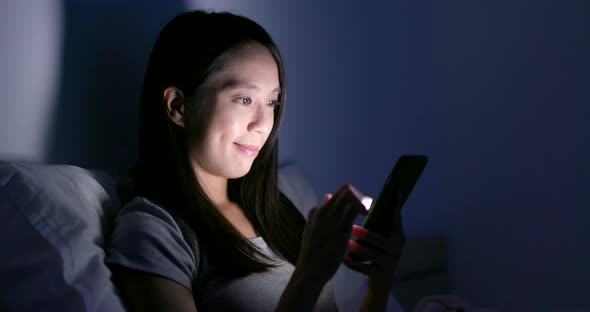 Woman Use of Smart Phone on Bed at Night