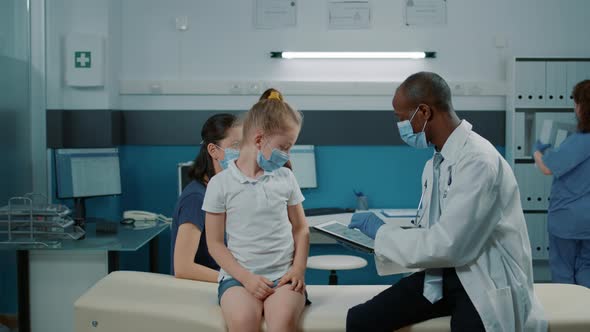 General Practitioner Using Digital Tablet to Take Notes at Examination