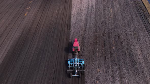 Tractor Plows Ground on Cultivated Farm Field