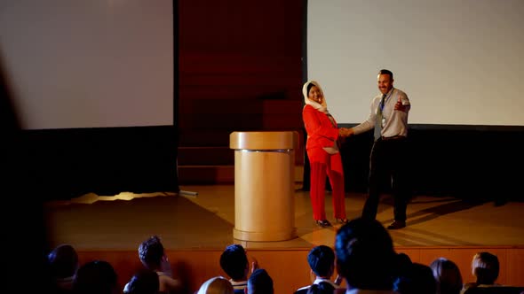 Multi-ethnic business people shaking hand on stage in business seminar at auditorium 4k