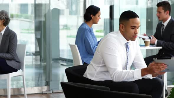 Businessman discussing over digital tablet with colleague