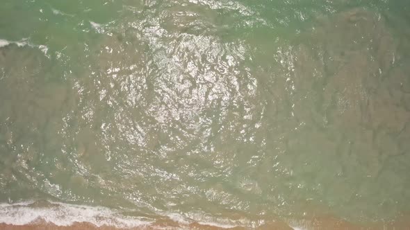 Top view amazing waves crashing on sandy shore. beautiful sea surface in phuket thailand