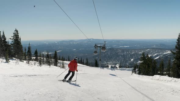 Experienced Skier Turns On Skis Sliding Down A Slope In The Mountains In Winter