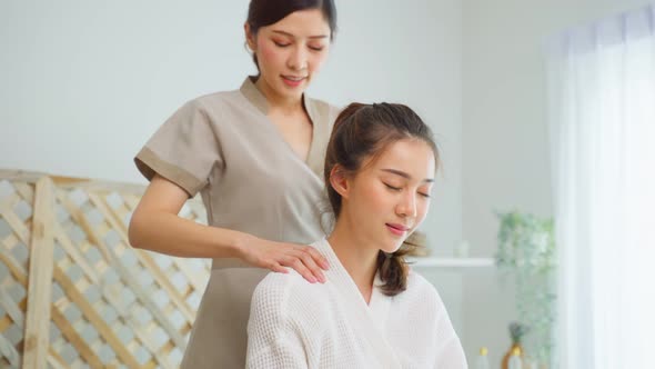 Asian young happy woman feeling relax during shoulder and back massage.